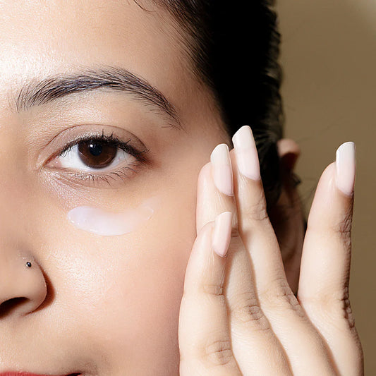 Woman applying hydrating eye cream under eye, close-up of healthy skin care routine