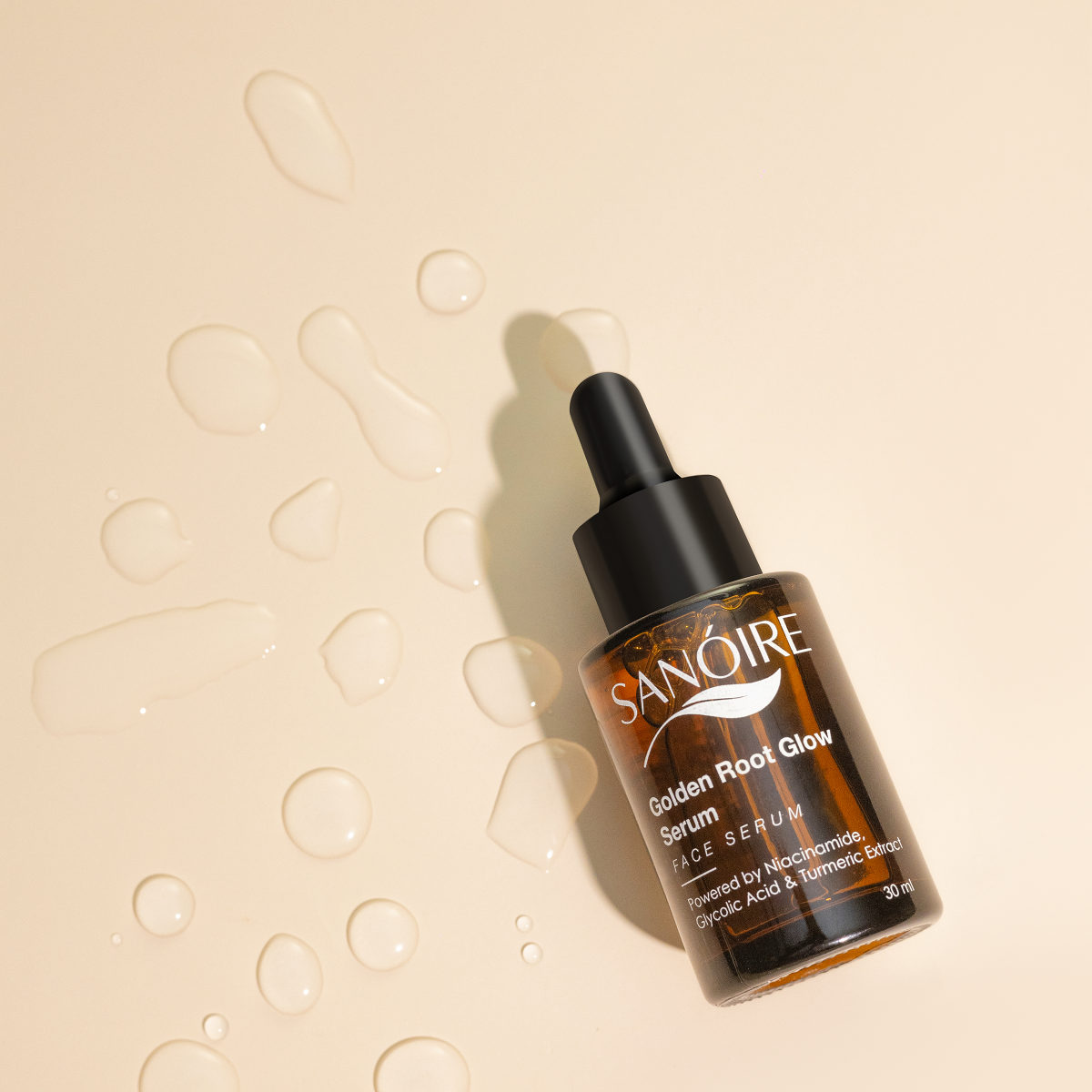 Dropper bottle of Golden Root Glow face serum on beige background with serum drops