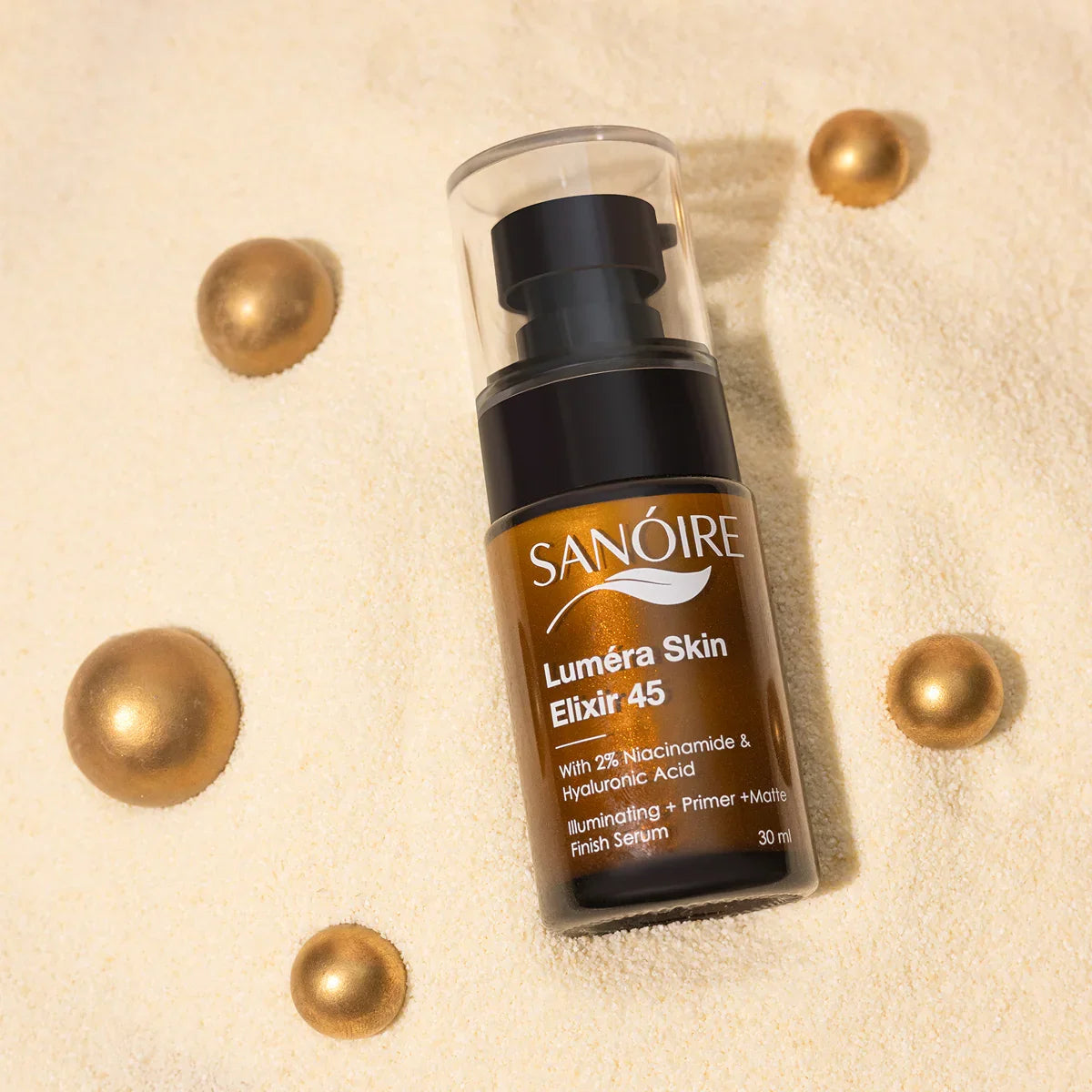 Luméra Skin Elixir 45 serum bottle with gold accents on sand, skincare product photography