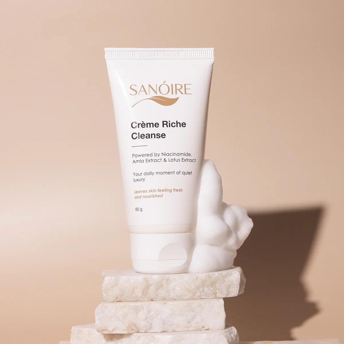 Crème Riche Cleanse skincare tube on marble with foamy texture, niacinamide cleanser