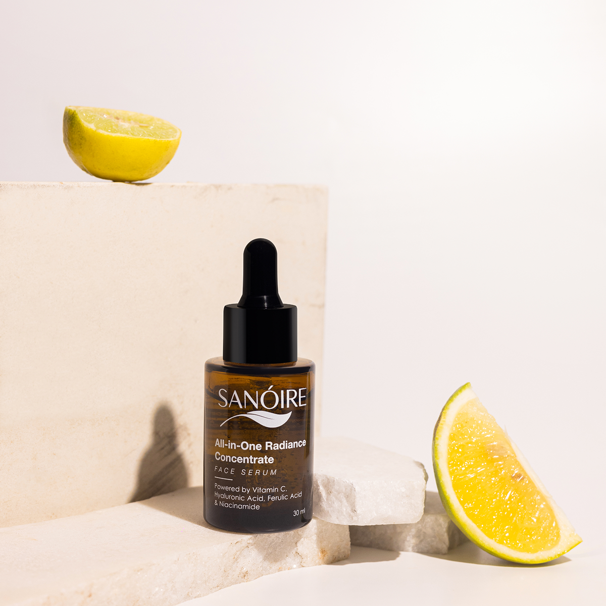 Radiance face serum bottle with dropper on stone, surrounded by lemon slices, skincare concept