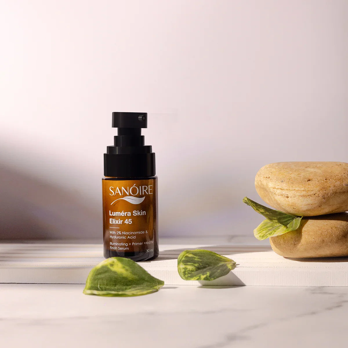 Luméra Skin Elixir 45 serum bottle with natural stones and leaves on a minimalist surface