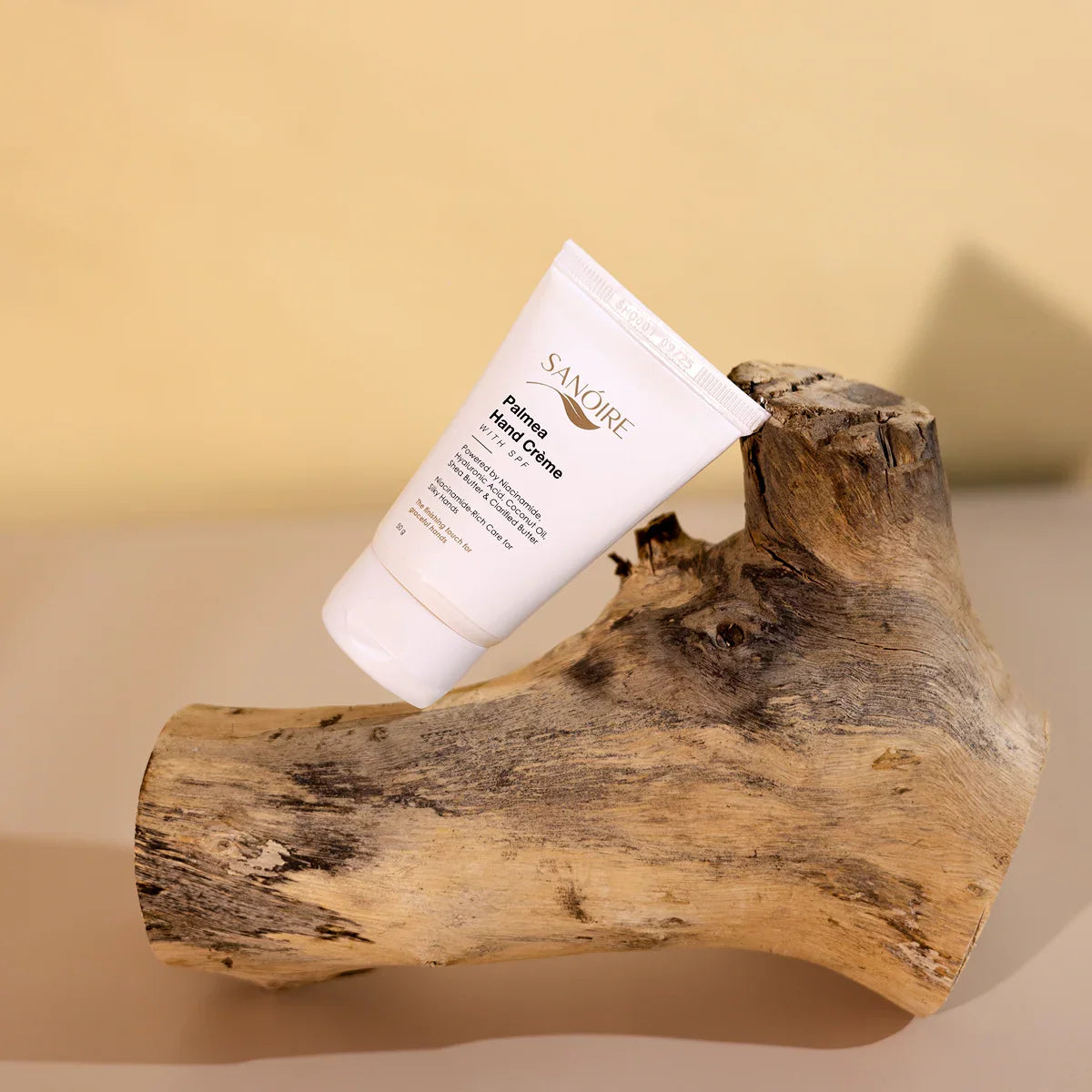 Hand cream tube on textured wood, minimalist background, skincare product display