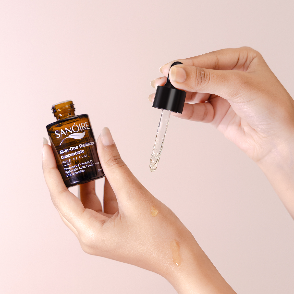 Hand applying Sanoire face serum with dropper, clear liquid on skin, skincare product