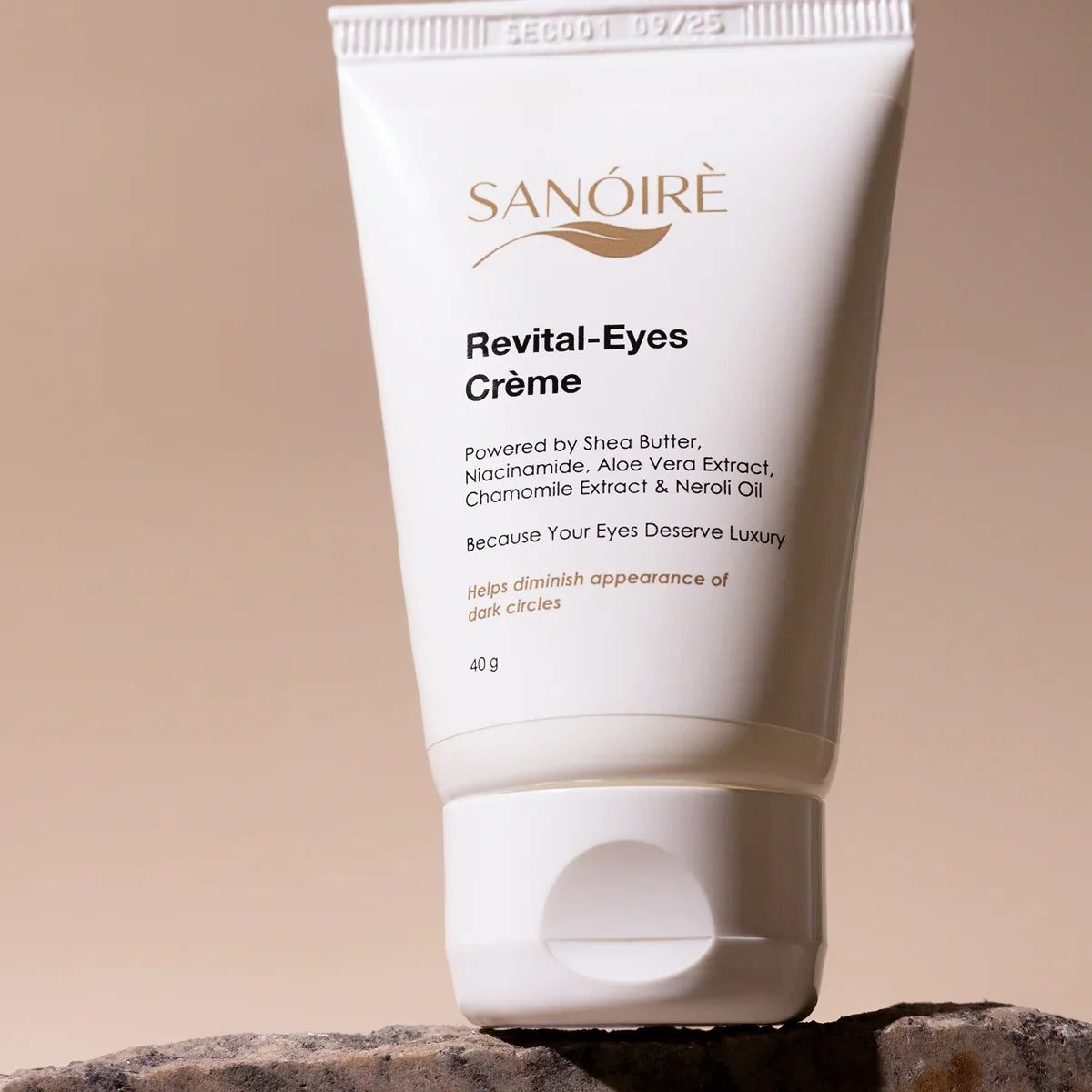 Revital-Eyes Crème eye cream tube with shea butter and niacinamide on a stone, beige background